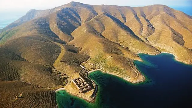 منظر جوي لساحل جبلي وعر تتخلله خلجان ذات مياه زرقاء وفيروزية، وتظهر مبانٍ عند أحد أطرافه.