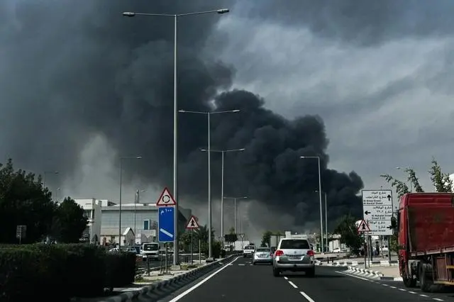 دخان كثيف رمادي داكن في خلفية طريق سريع بعد هجوم إيراني مزعوم في المنطقة الصناعية بالدوحة
