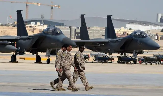 ضباط في الجيش السعودي يمرّون أمام مقاتلات من طراز "إف-15" وقنابل "جي بي يو" وصواريخ معروضة خلال حفل بمناسبة الذكرى الخمسين لتأسيس كلية الملك فيصل الجوية، في قاعدة الملك سلمان الجوية بالرياض، في 25 يناير/كانون الثاني 2017.